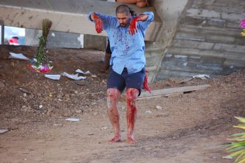 Still from performance under the 4th St viaduct in Boyle Heights accompanied by Sebastian Hernandez, no water under the bridge, 2014, dyed hung flowers, mortar, water, tree sap, smoke, artist's blood. Rafael Esparza