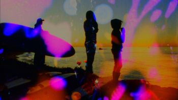 Film still: Dawn Surf Jellybowl Film (16mm film negative sanded with surfboard shaping tools, sex wax melted on, squirted, dripped, splashed, sprayed and rubbed with donuts, zinc oxide, cuervo, sunscreen, hydrogen peroxide, tecate, sand, tar, scraped with a shark's tooth, edits made by the surf and a seal while film floated in waves- surfing performed by Andy Perry, Makela Moore, Alanna Moore, Zach Moore, Johnny McCann - shot by Peter West - film negative sanded by Mariah Csepanyi, Andy Perry and Jwest), 2011, 8 minutes 15 seconds
16mm film negative transferred to high definition video, projector, projection screen, beer bottle caps, blankets, pillows
Commissioned by the Contemporary Arts Forum, Santa Barbara, California and Thanks to Andy Perry Jennifer West