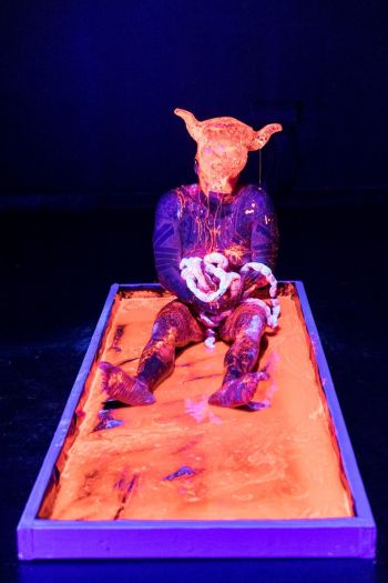 Acephalous Monster; 2018; performance; scene: “Apotheosis”; UV reactive solution, nylon “guts”, clear resin casting of Minotaur head Ron Athey
