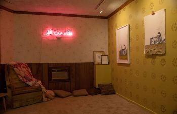 Installation view (1) of Exit Strategies; 2018; neon sign, carpet, wallpaper, wood laminate, latex paint, and acquired furniture, framed documents: acetone transfers on archival paper Yasmine Diaz