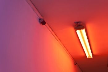 Doppler.Shift; 2014; colored gels, fluorescent light, stereo sound, speakers and DVD player; dimensions variable Yann Novak